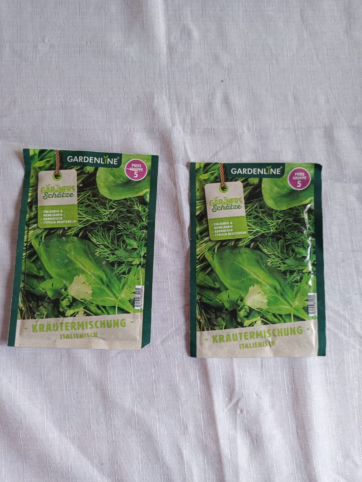 Two green Garden & Eat seed packets on a light gray fabric background