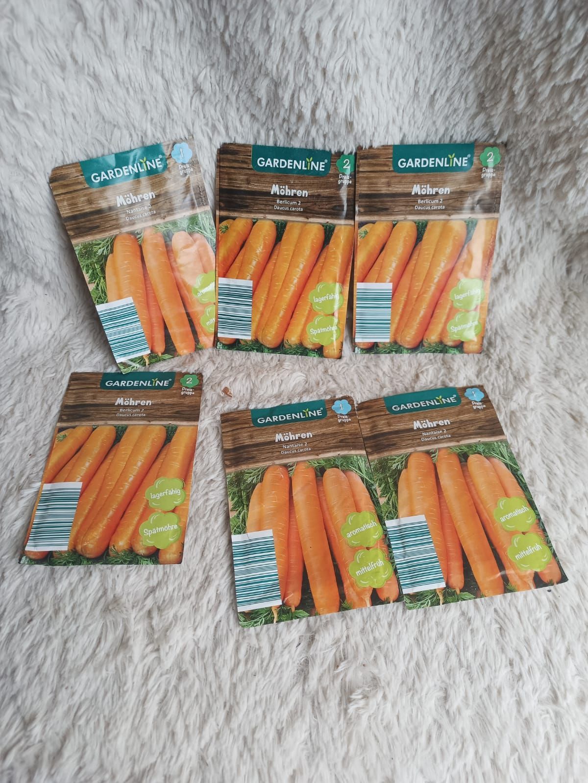 Five packets of orange-and-green candy or snack bars arranged on a white textured surface