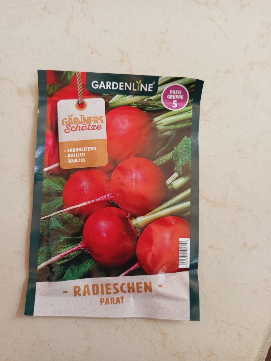 Radieschen seed packet with red radishes and green leaves on a light surface
