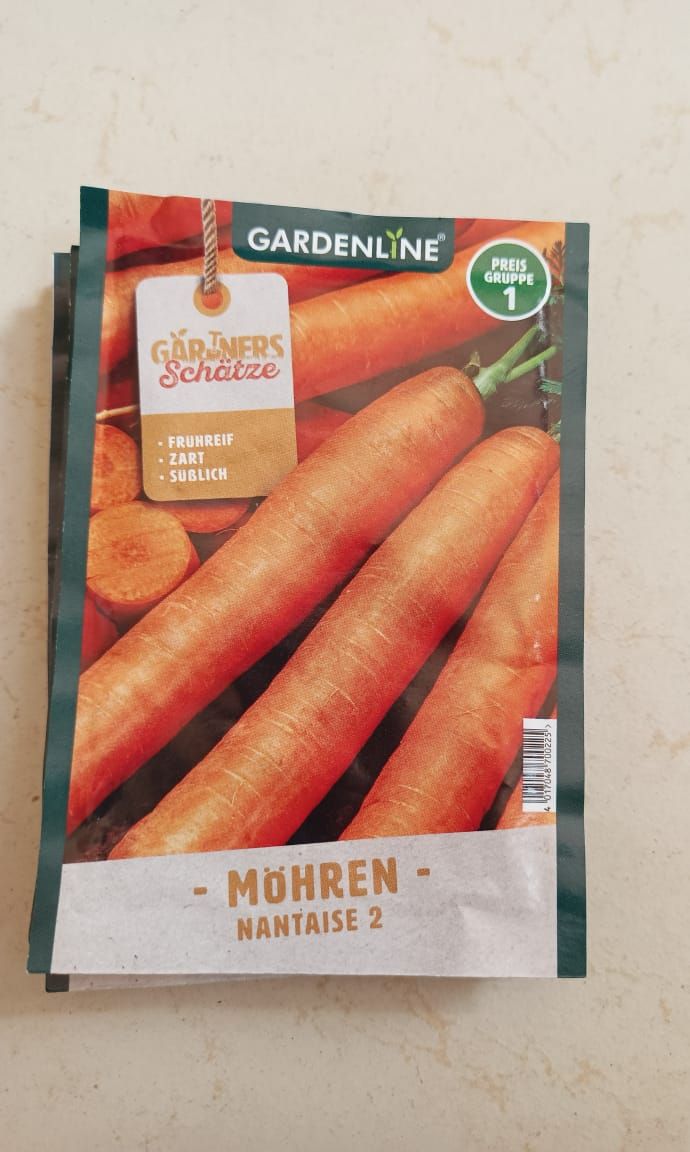 Seed packet for orange carrots, labeled “Möhren” with three carrots on the front.
