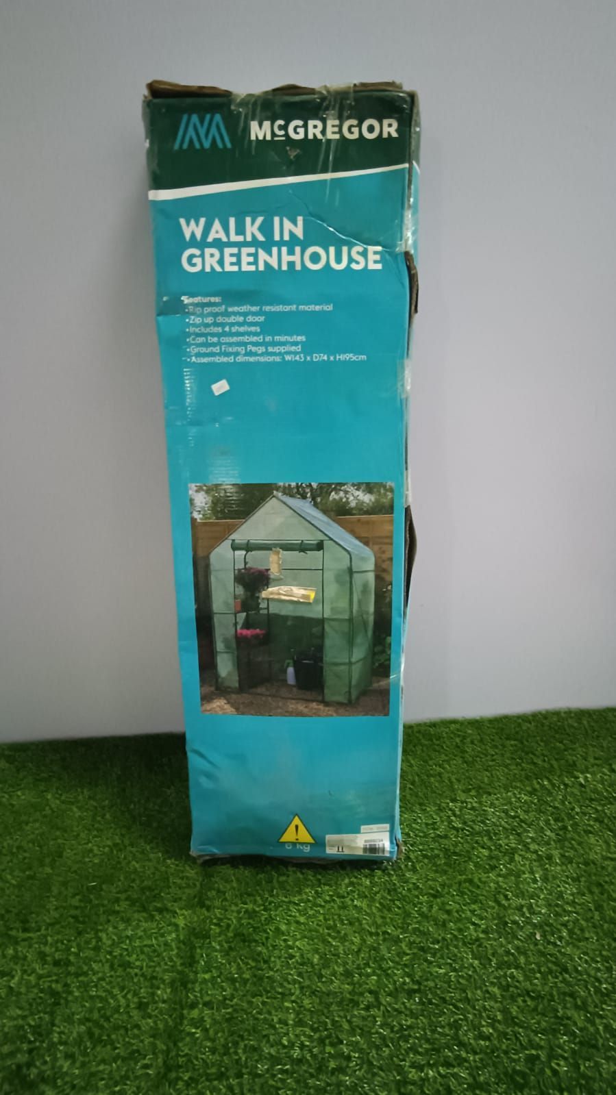 McGregor Walk-in Greenhouse box standing on artificial grass, teal packaging with greenhouse photo