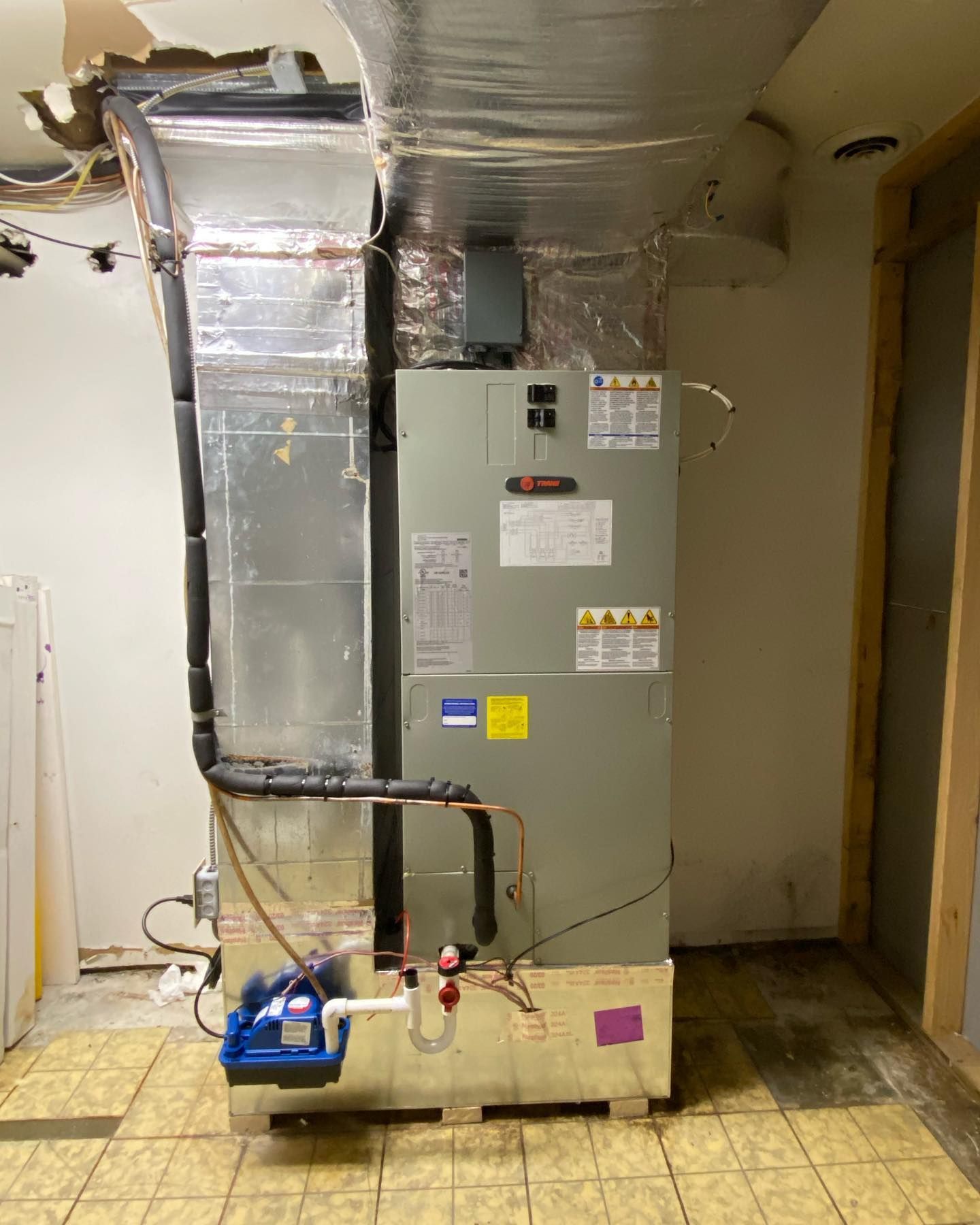 A large air conditioner is sitting in a room next to a wall.