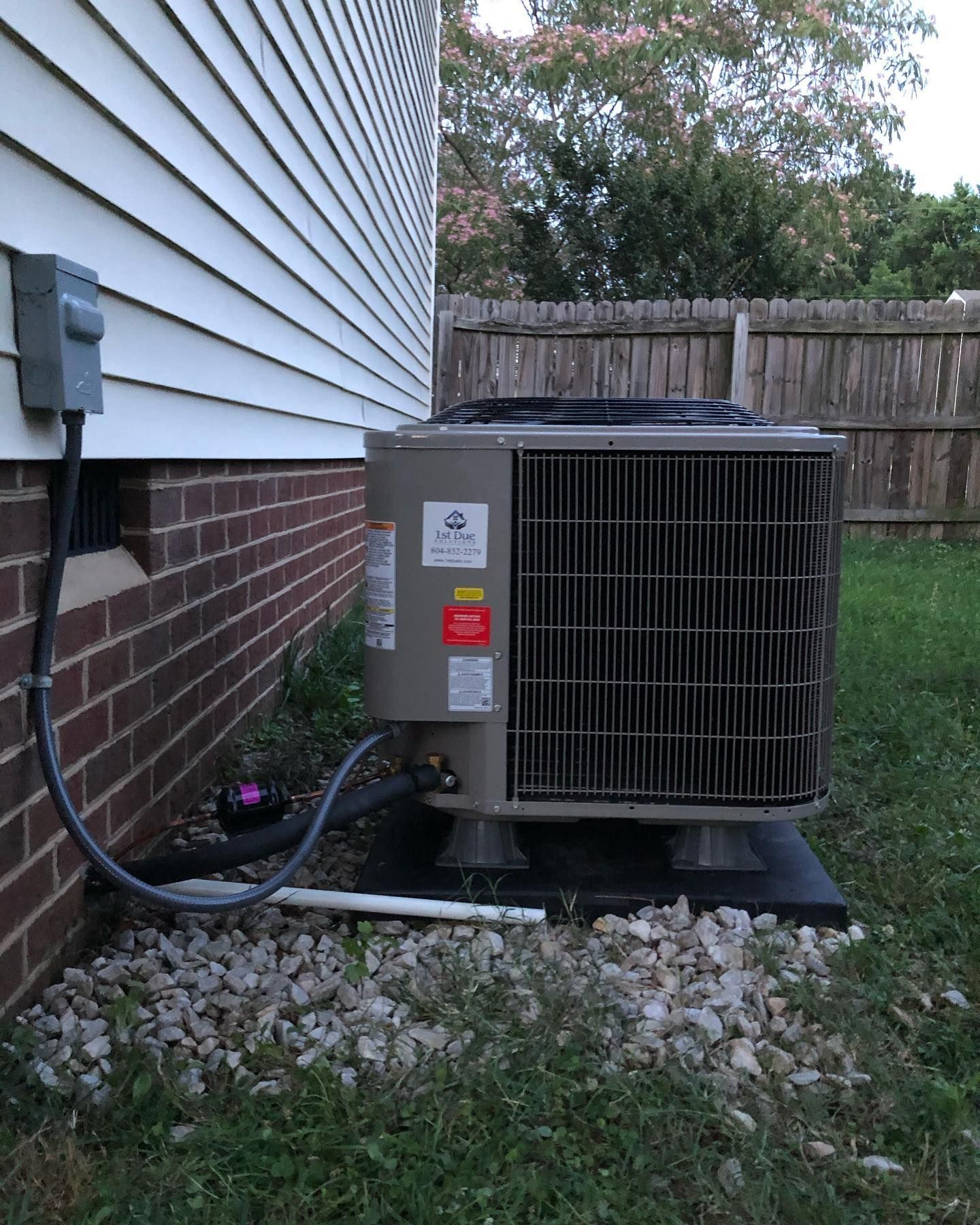 An air conditioner is attached to the side of a house