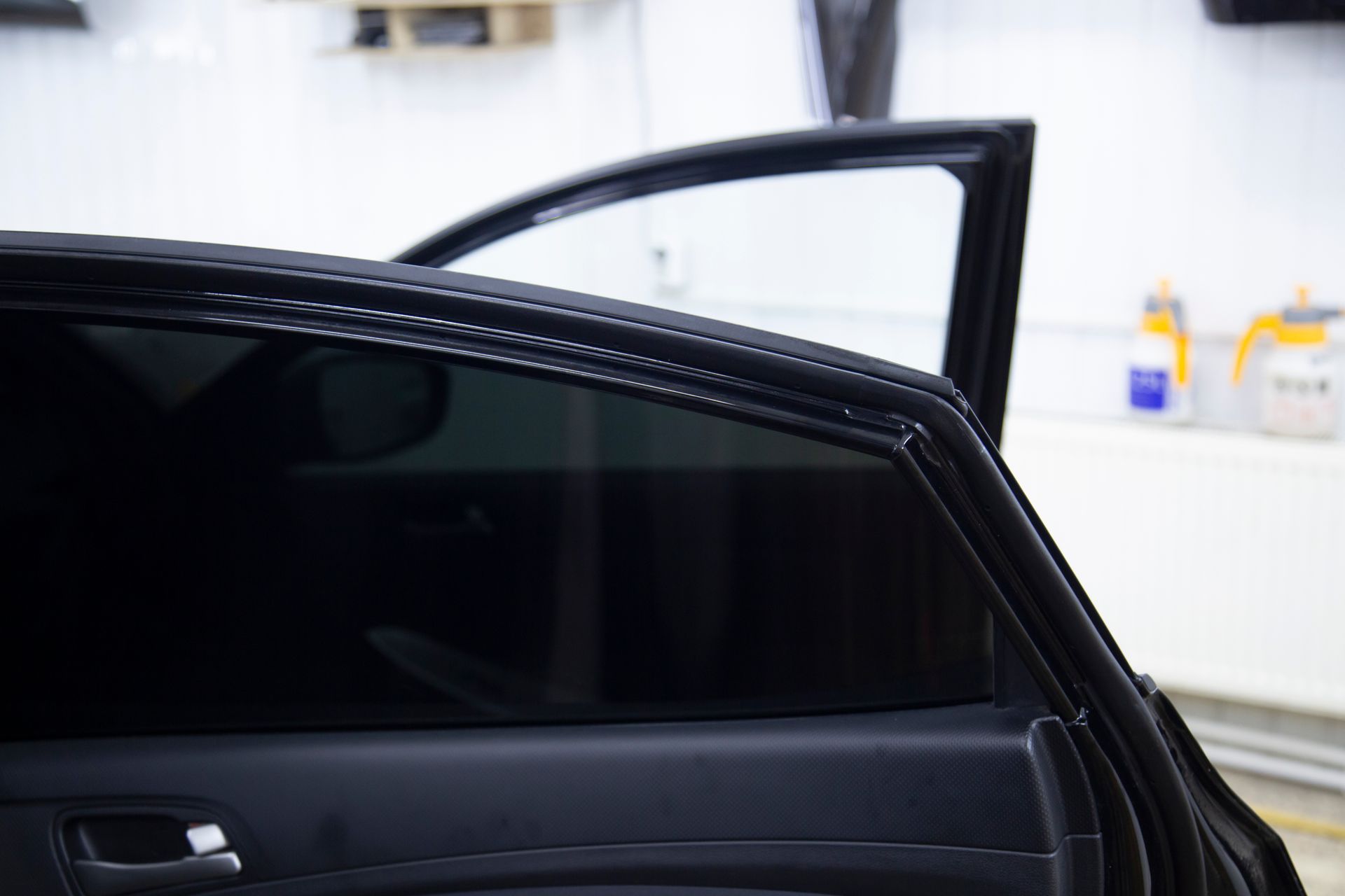 Open car door with tinted window in a bright garage