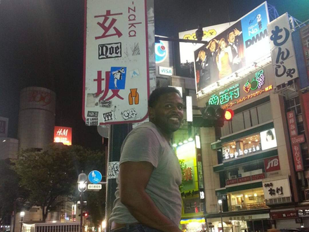 A man is standing in front of a sign that says zako