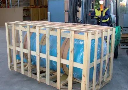 A forklift is carrying a large barrel in a wooden crate.