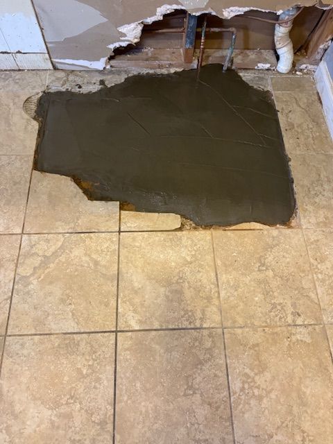 A hole in the floor is being filled with concrete