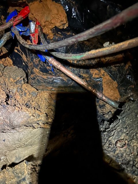 A bunch of wires are laying on the ground in a dark room