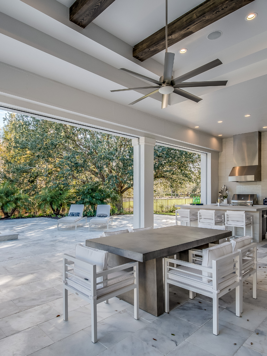 A dining room with a table and chairs and a ceiling fan