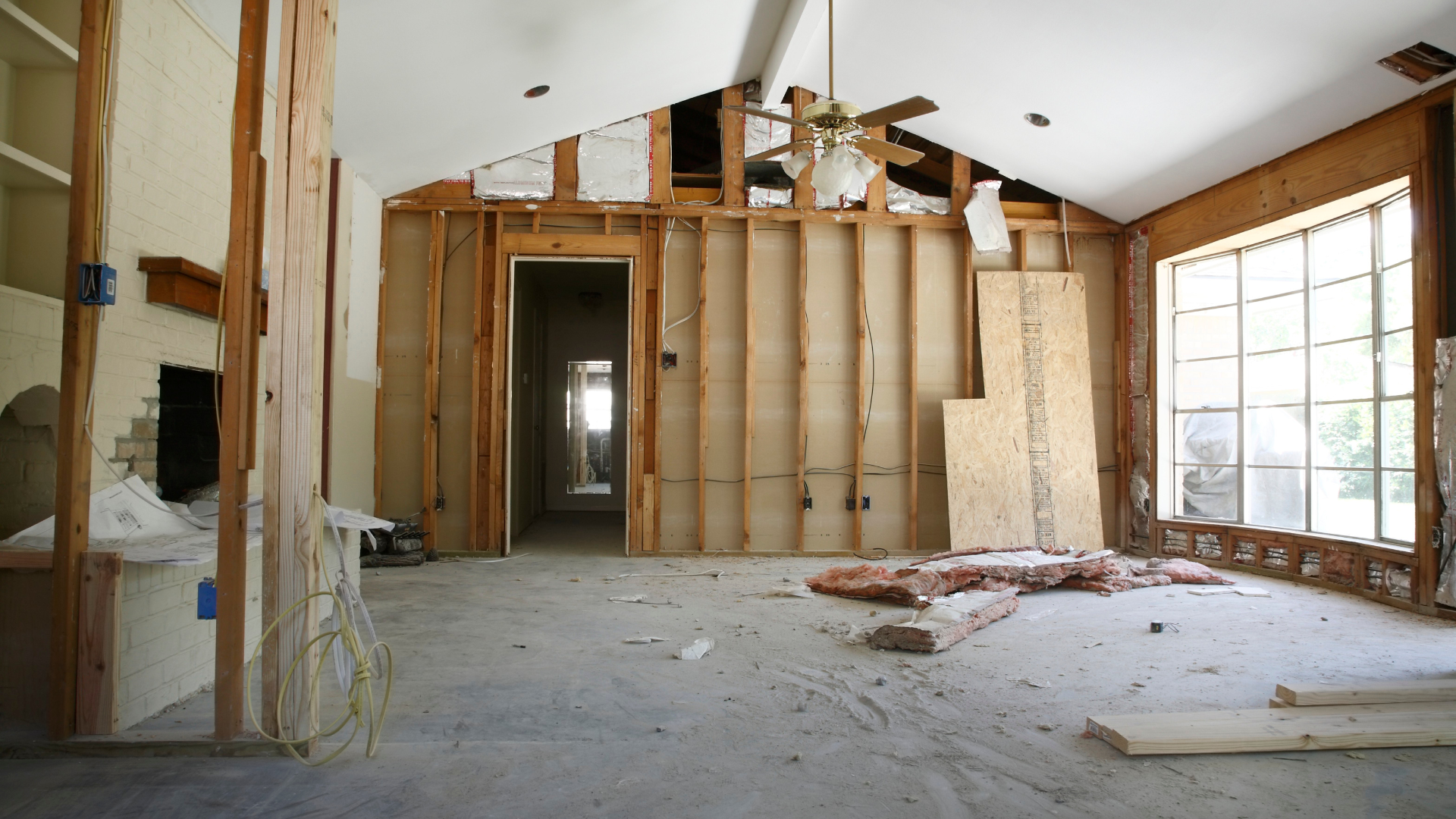 An empty room with a ceiling fan and a lot of windows