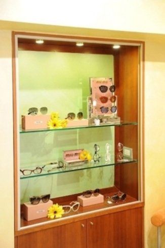 a pair of sunglasses sitting on top of a pink box next to a yellow flower .