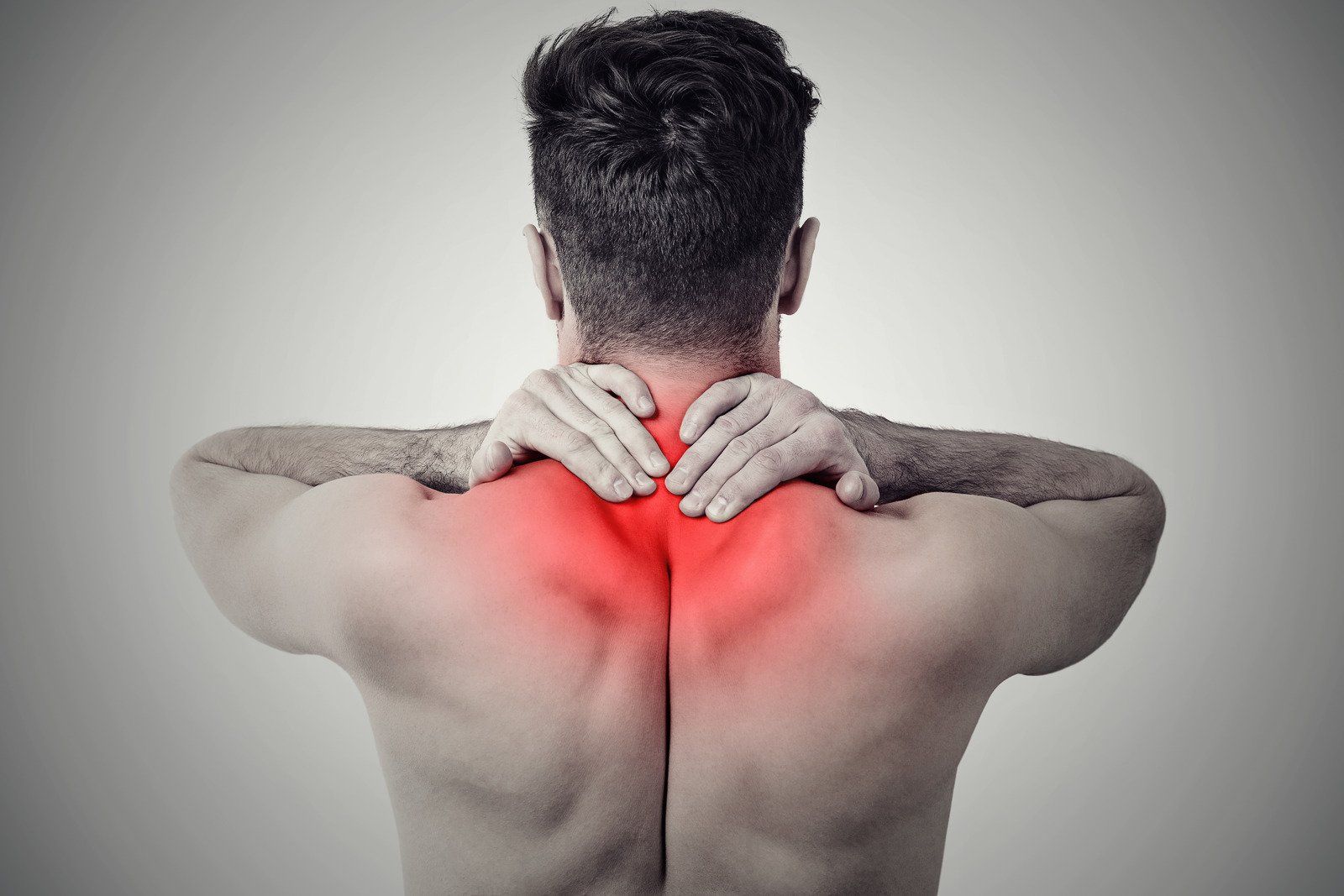 A man is holding his neck in pain.