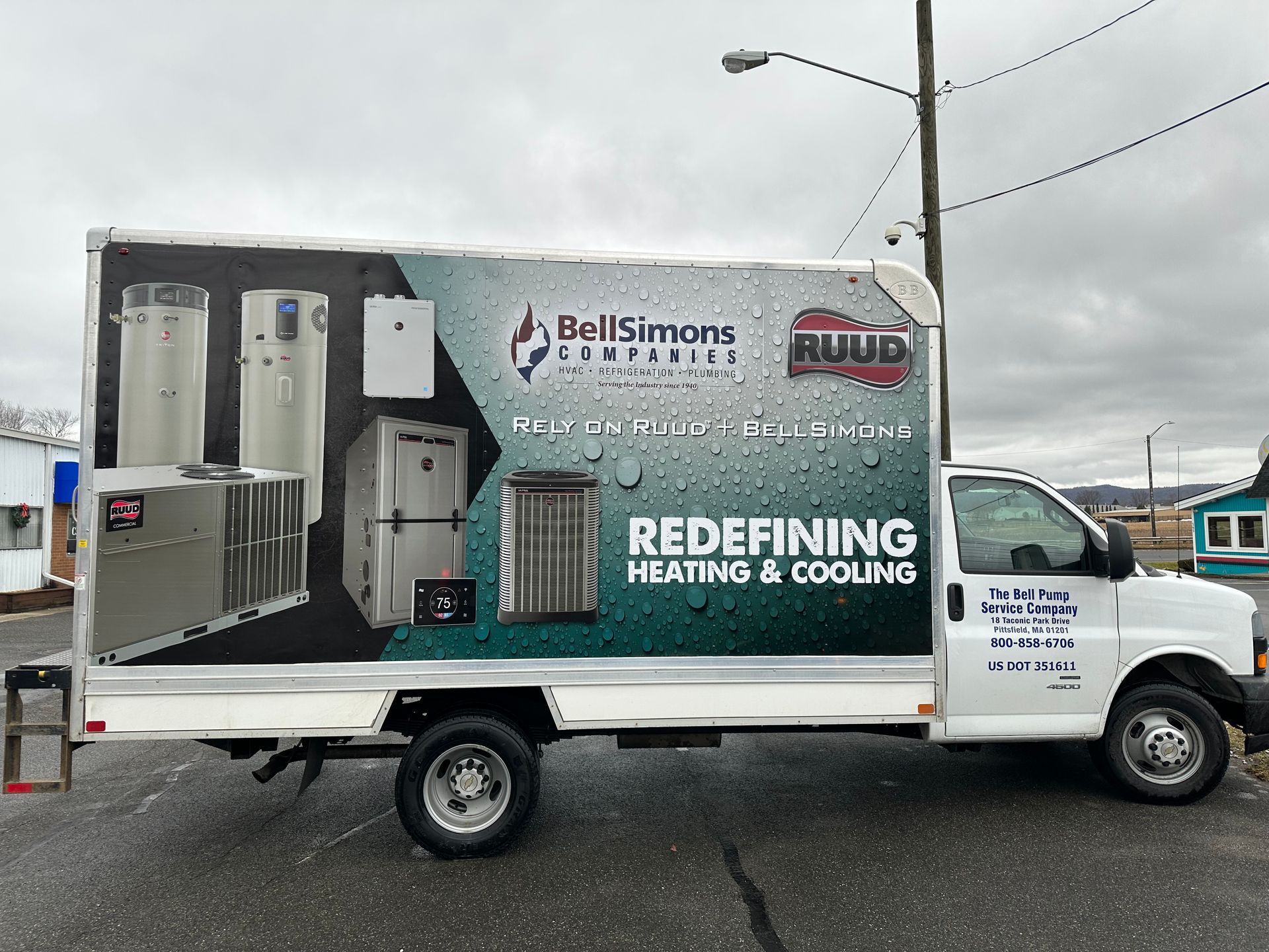 A white truck with a sticker on the side that says redefining heating and cooling.