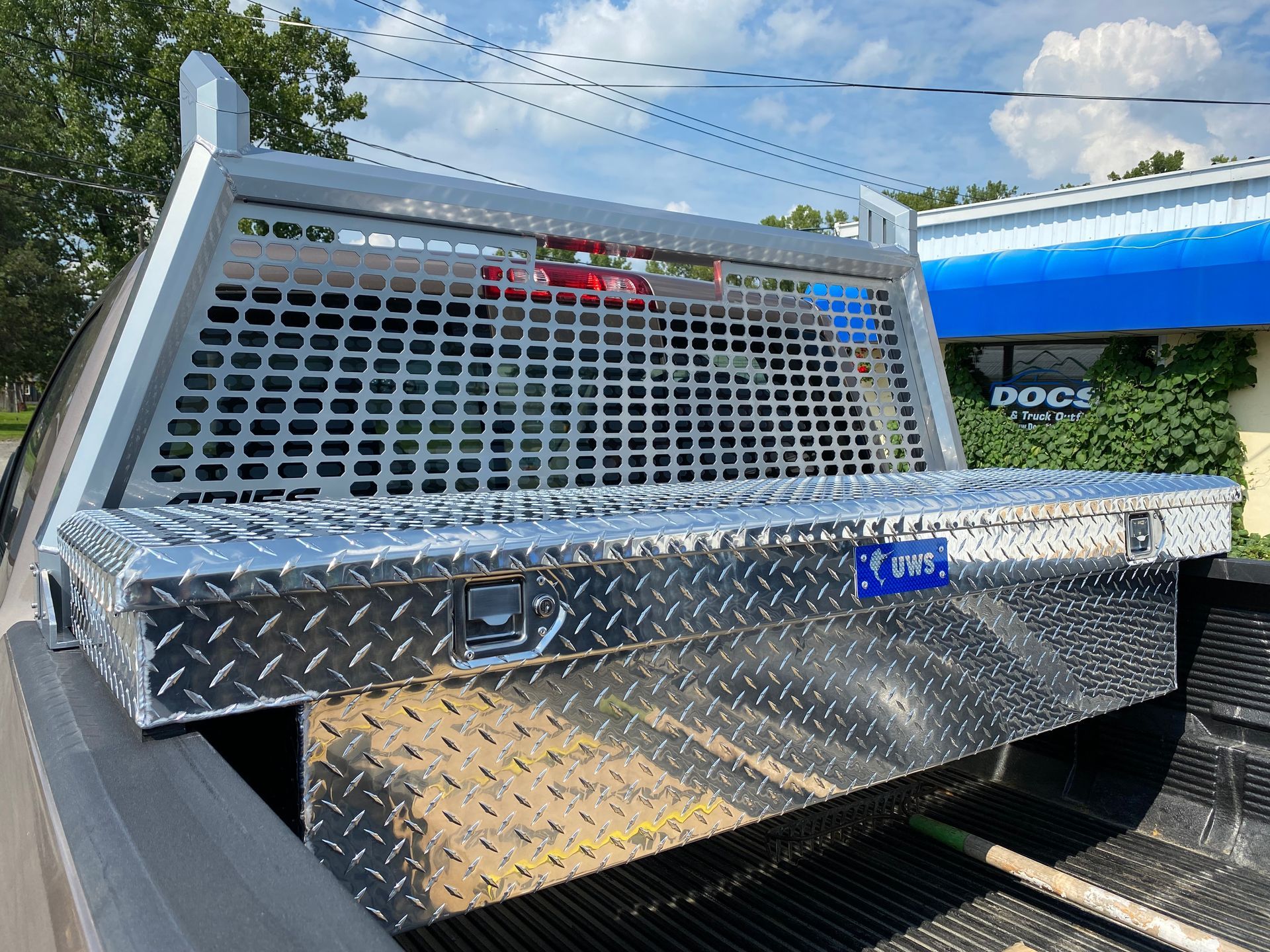 A truck with a headache rack and a toolbox in the bed.
