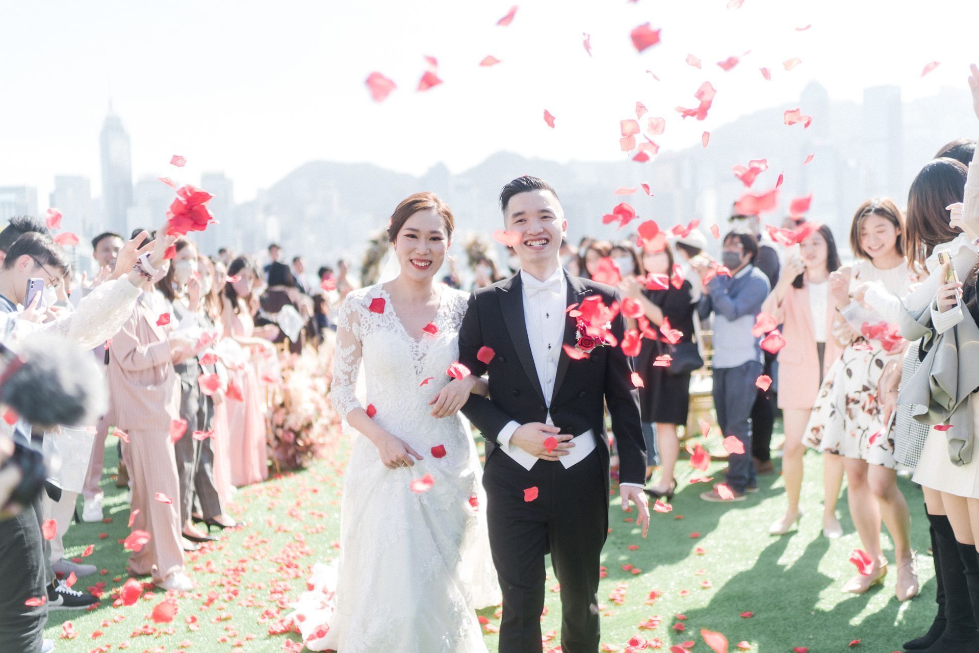 A bride and groom are walking down the aisle surrounded by confetti.