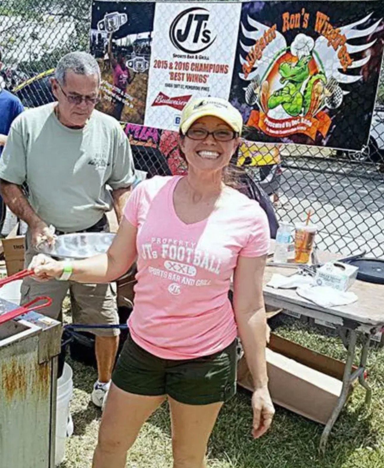 A woman wearing a pink shirt that says ' it 's football ' on it