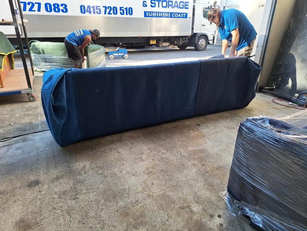 Movers Loading a Blue-covered Couch Onto a Truck at a Storage Facility 
— John's Furniture Removals in Sunshine Coast, QLD