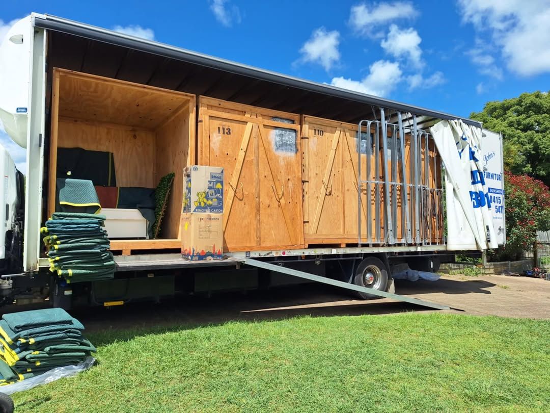 Moving Truck With Ramp Open, Wooden Crates Inside, Parked on Grass — John's Furniture Removals in Sunshine Coast, QLD