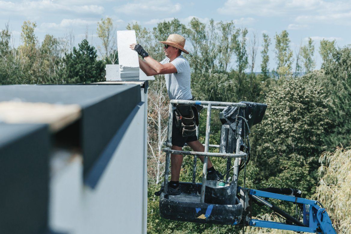 A Man is Cleaning the Side of a Building That Says Sunshine Coast — Commercial Asset Maintenance In Beerwah, QLD