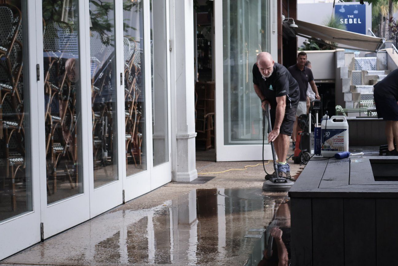 A Man is Cleaning the Floor of a Store With a Machine — Commercial Asset Maintenance In Gympie, QLD