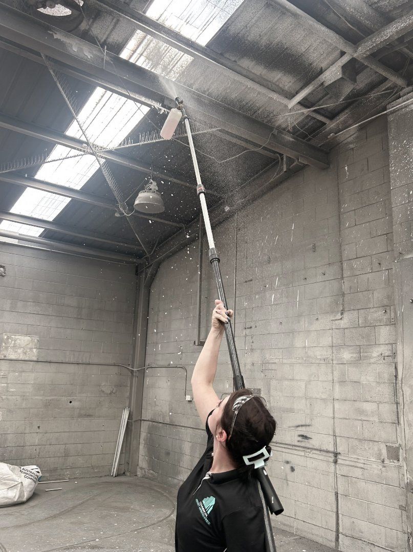 A Man is Cleaning a Carpet With a Vacuum Cleaner — Commercial Asset Maintenance In Caloundra, QLD