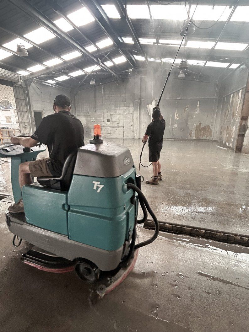 A Man is Cleaning the Floor of a Building With a Mop — Commercial Asset Maintenance In Brisbane, QLD
