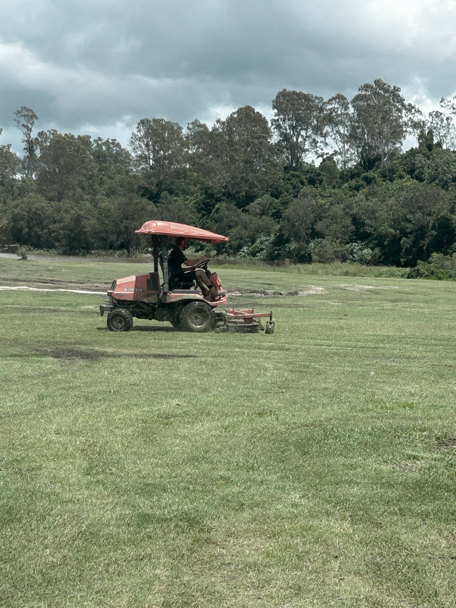A Tractor Mowing a Green Field — Commercial Asset Maintenance In Maroochydore, QLD