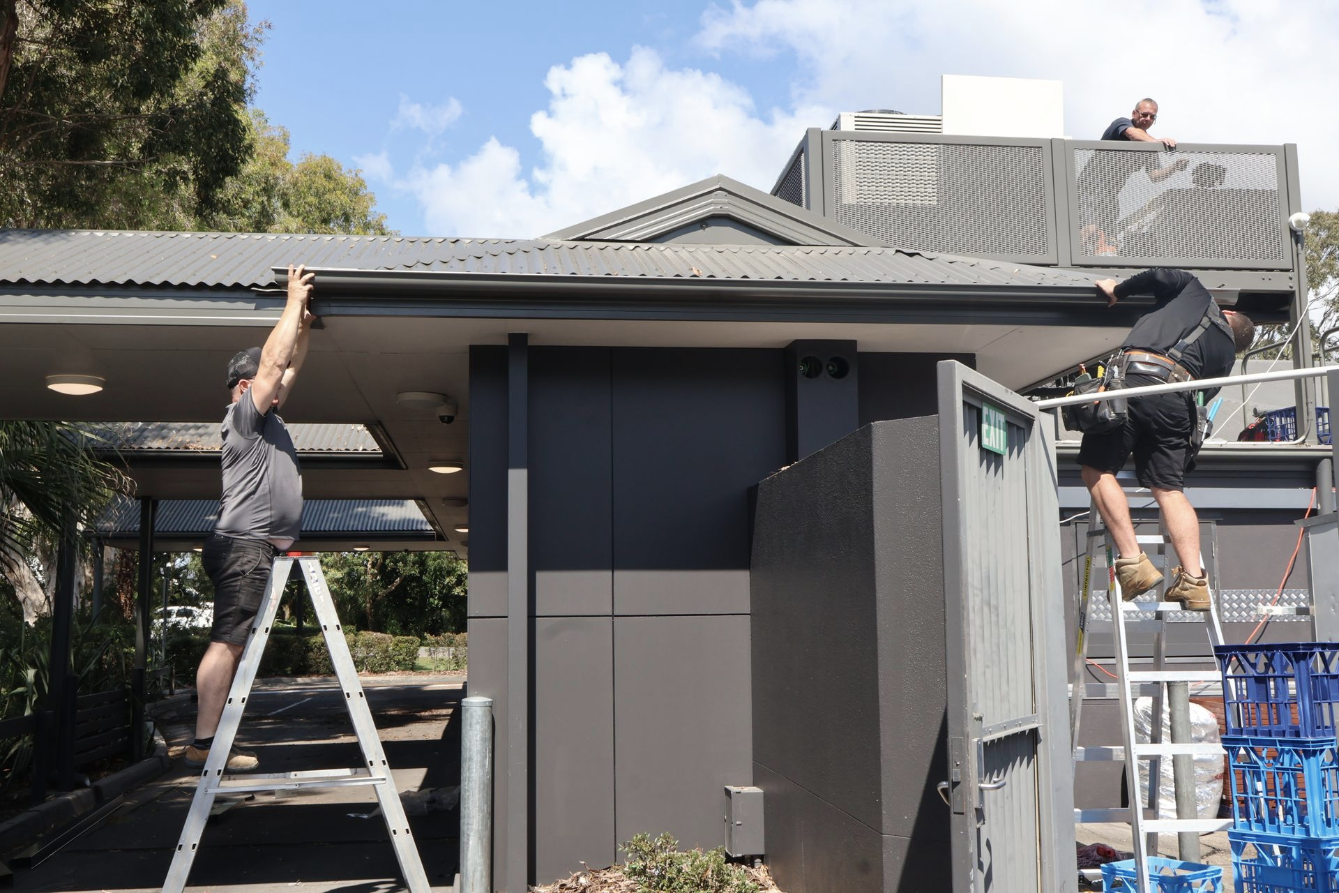 Two Workers on Ladders Installing Roofing — Commercial Asset Maintenance In Noosa, QLD