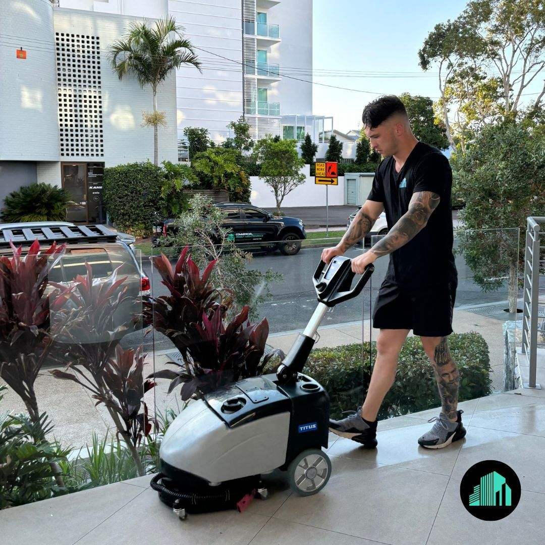 A Man Cleaning a Building Entrance with A Machine — Commercial Asset Maintenance In Morayfield, QLD