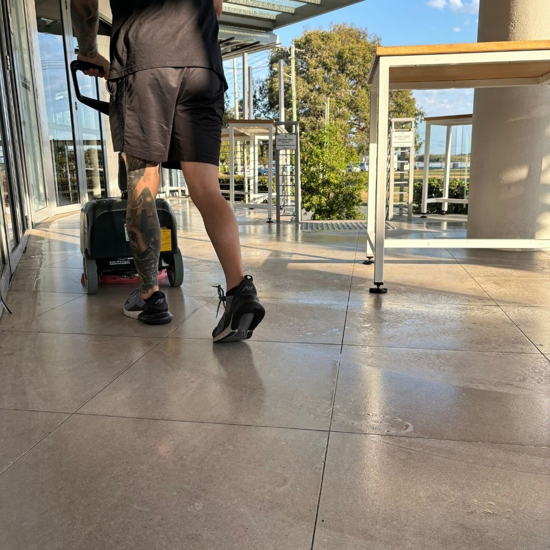 A Person Cleaning an Outdoor Patio with A Machine — Commercial Asset Maintenance In Bribie Island, QLD