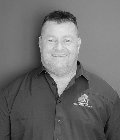 Man in button-down shirt smiles; logo on shirt reads