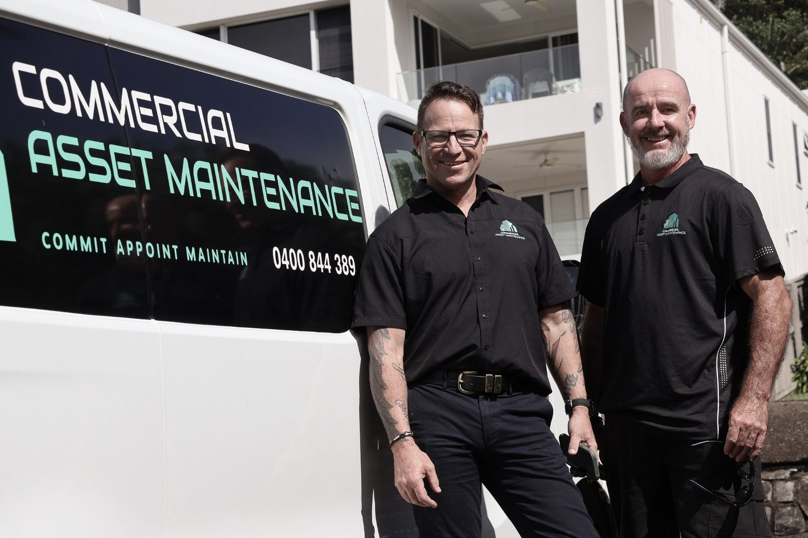 Two men stand beside a white van with