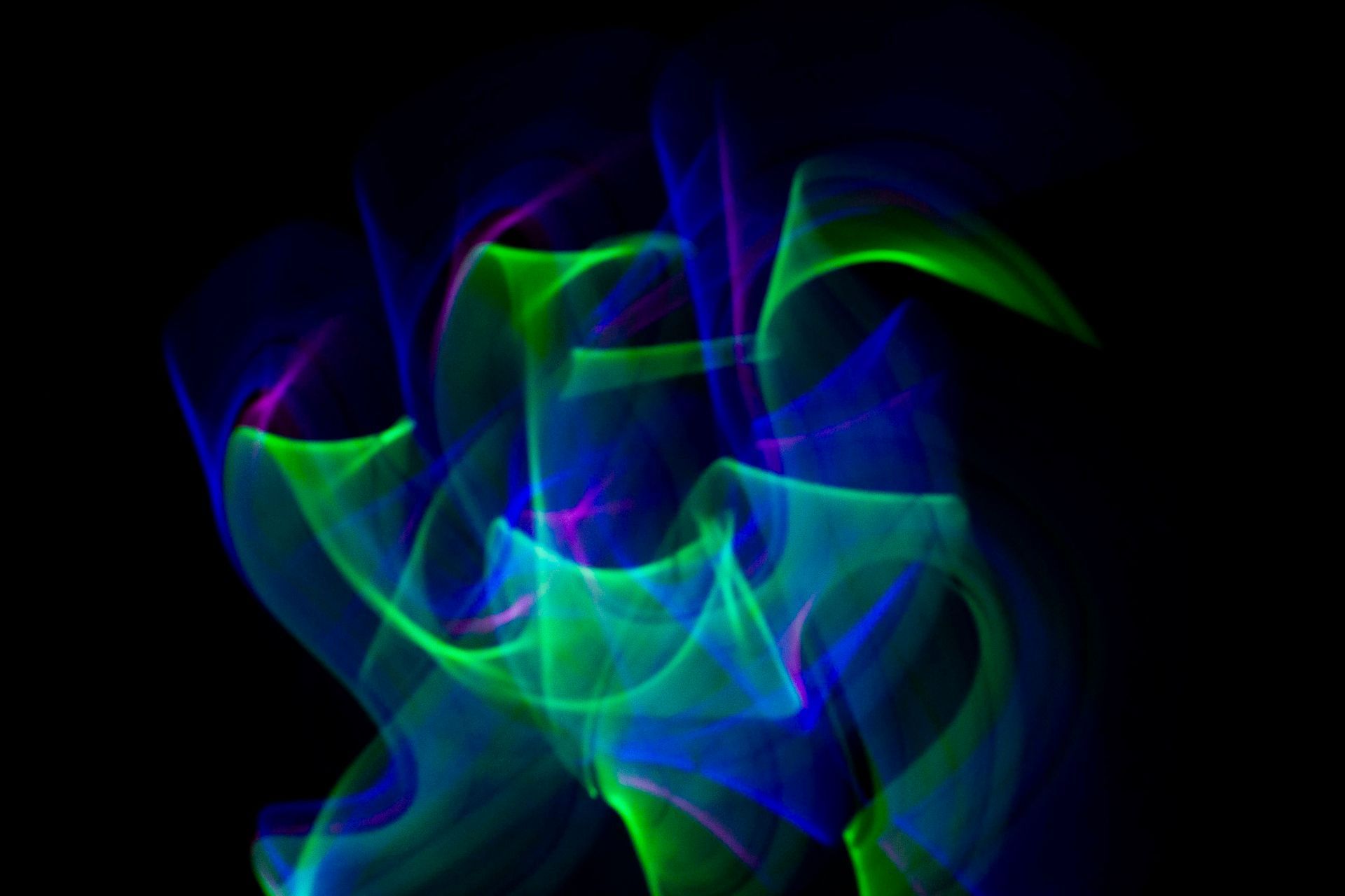 Blue and green waves of light on a black background