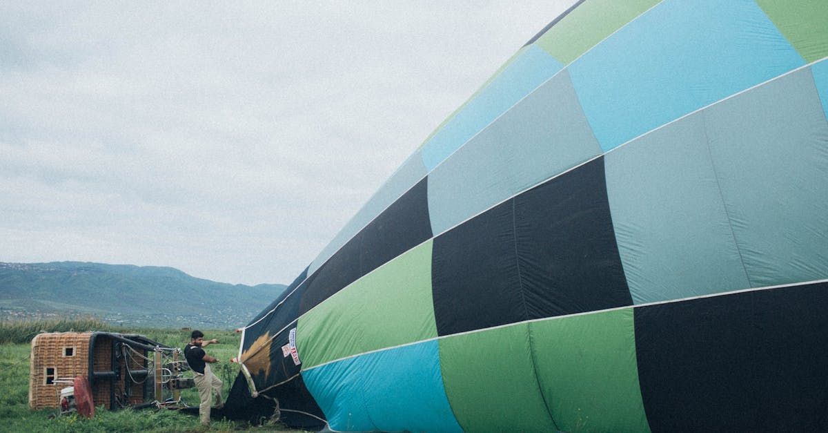 A colorful hot air balloon is being inflated in a field.