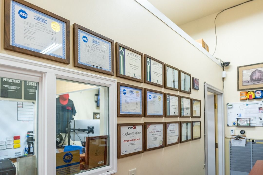 Wall with framed certificates in an office setting.