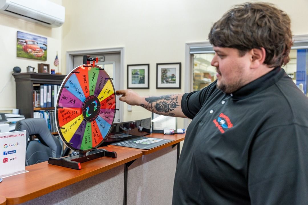 Man spinning a colorful prize wheel in an office setting.