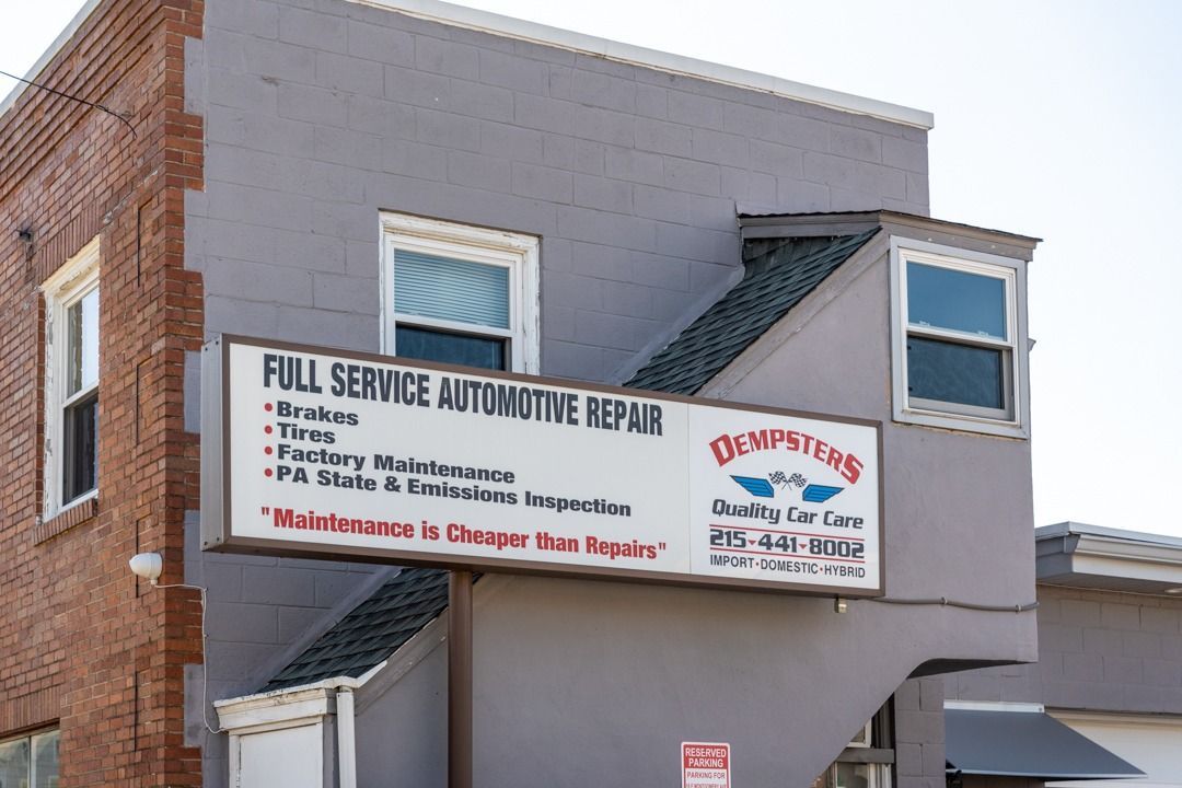 Automotive repair shop sign: gray building, brick side,