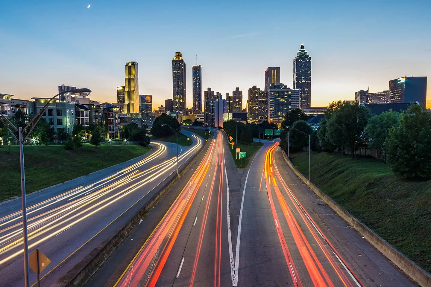 A long exposure photo of a highway with a city skyline in the background.