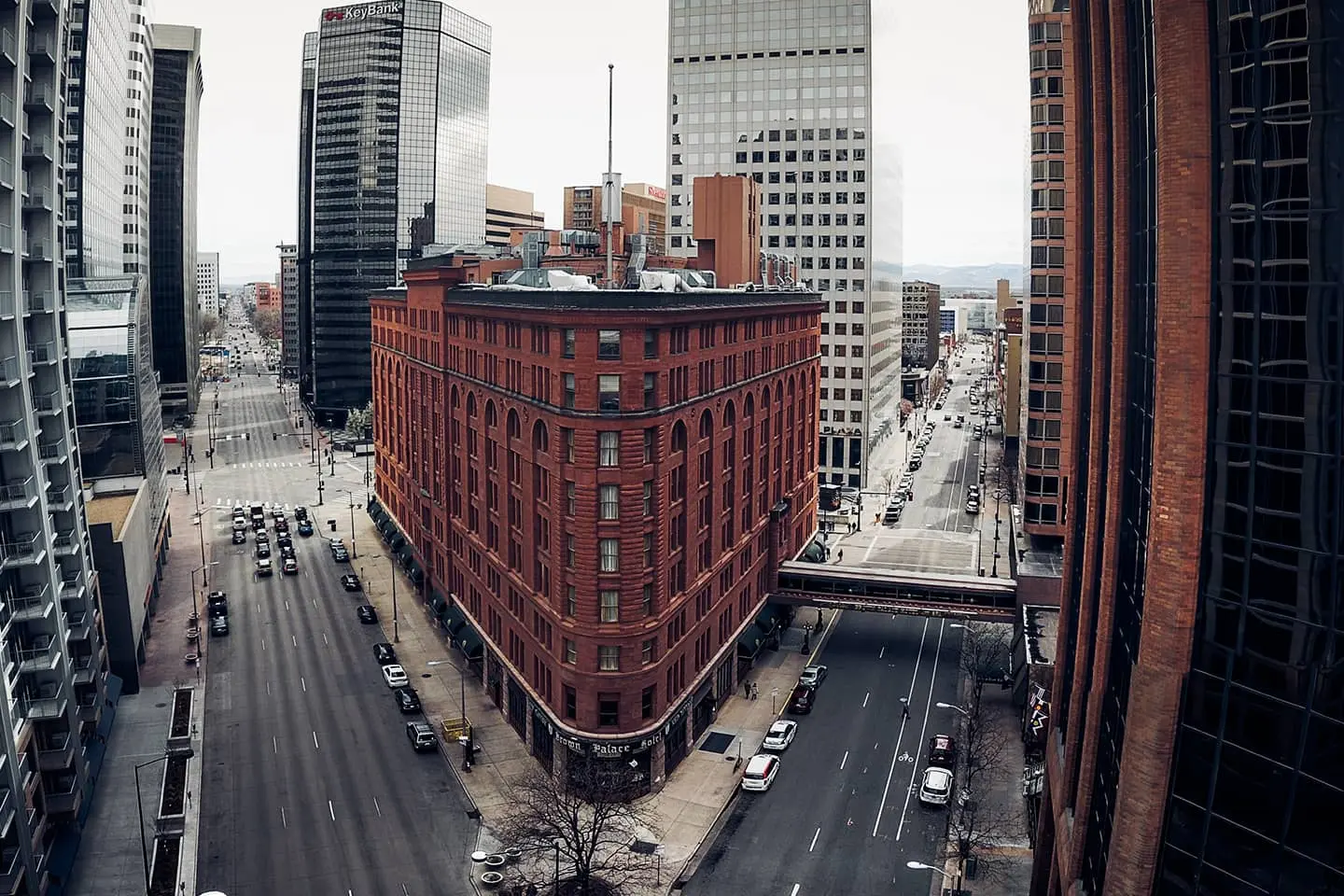 An aerial view of a city street with a large brick building in the middle.