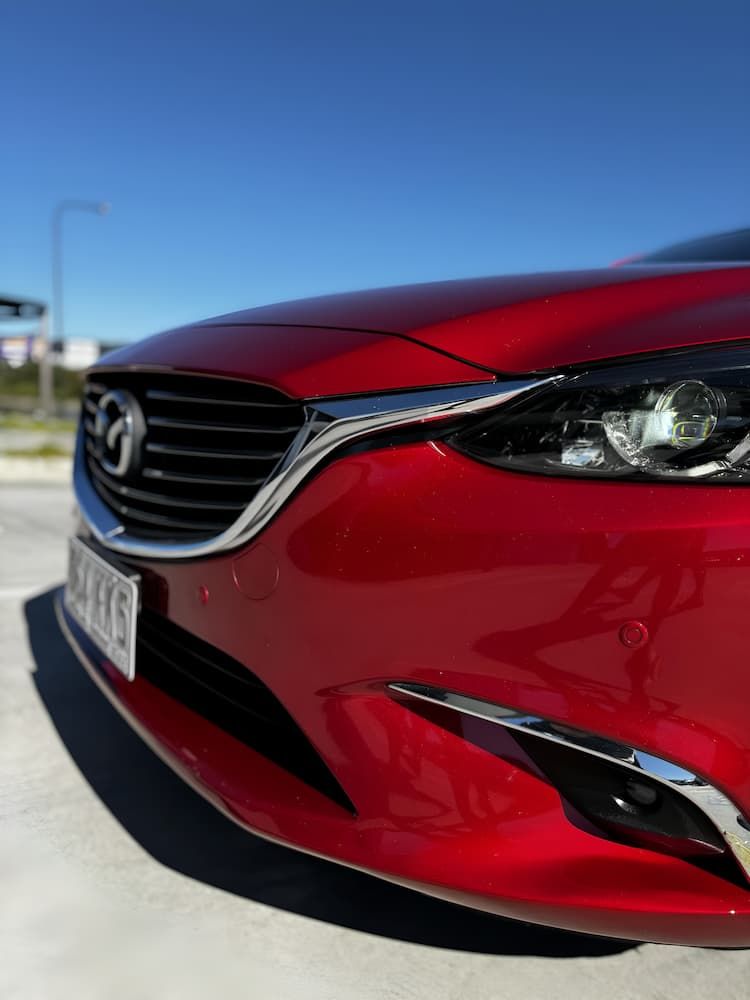 A Red Mazda Car is Parked on the Side of the Road — Silver Spanner Mechanics in Branyan, QLD