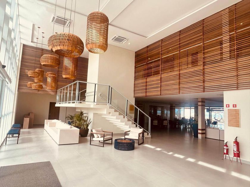 Hall de entrada moderno com escadaria branca, luminárias pendentes de vime e persianas de madeira, banhado por luz solar aconchegante.