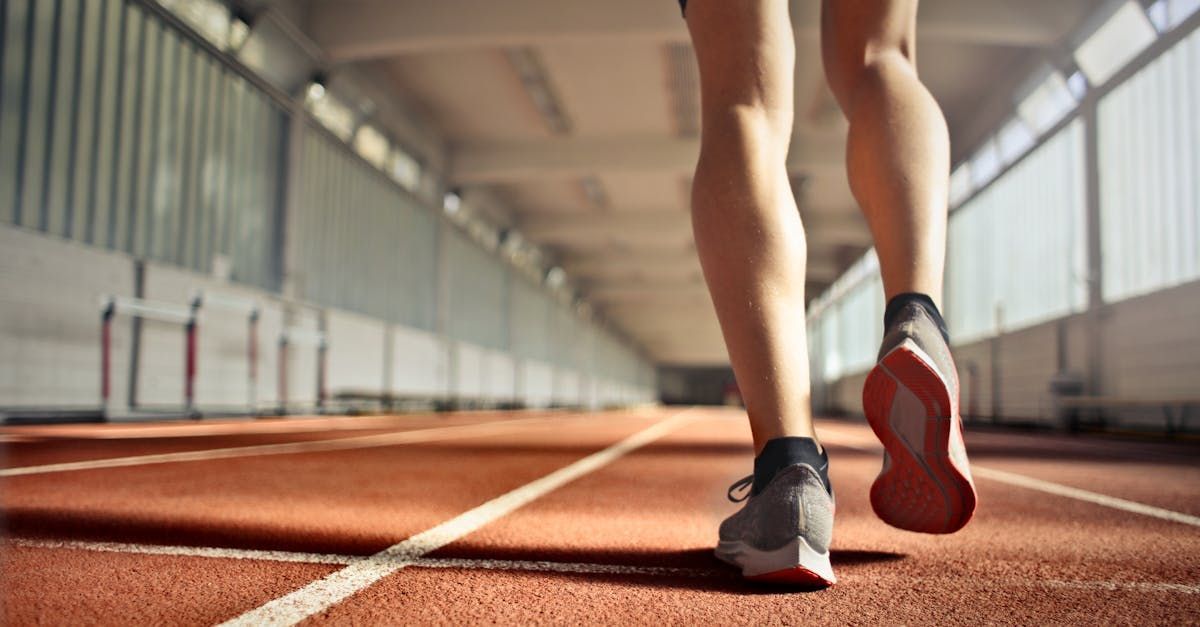 A person is running on a track in a stadium.