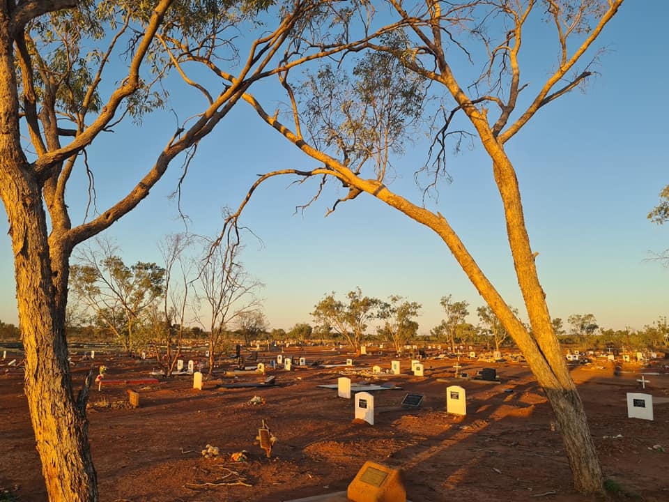 A cemetery in a dry, sunny landscape.