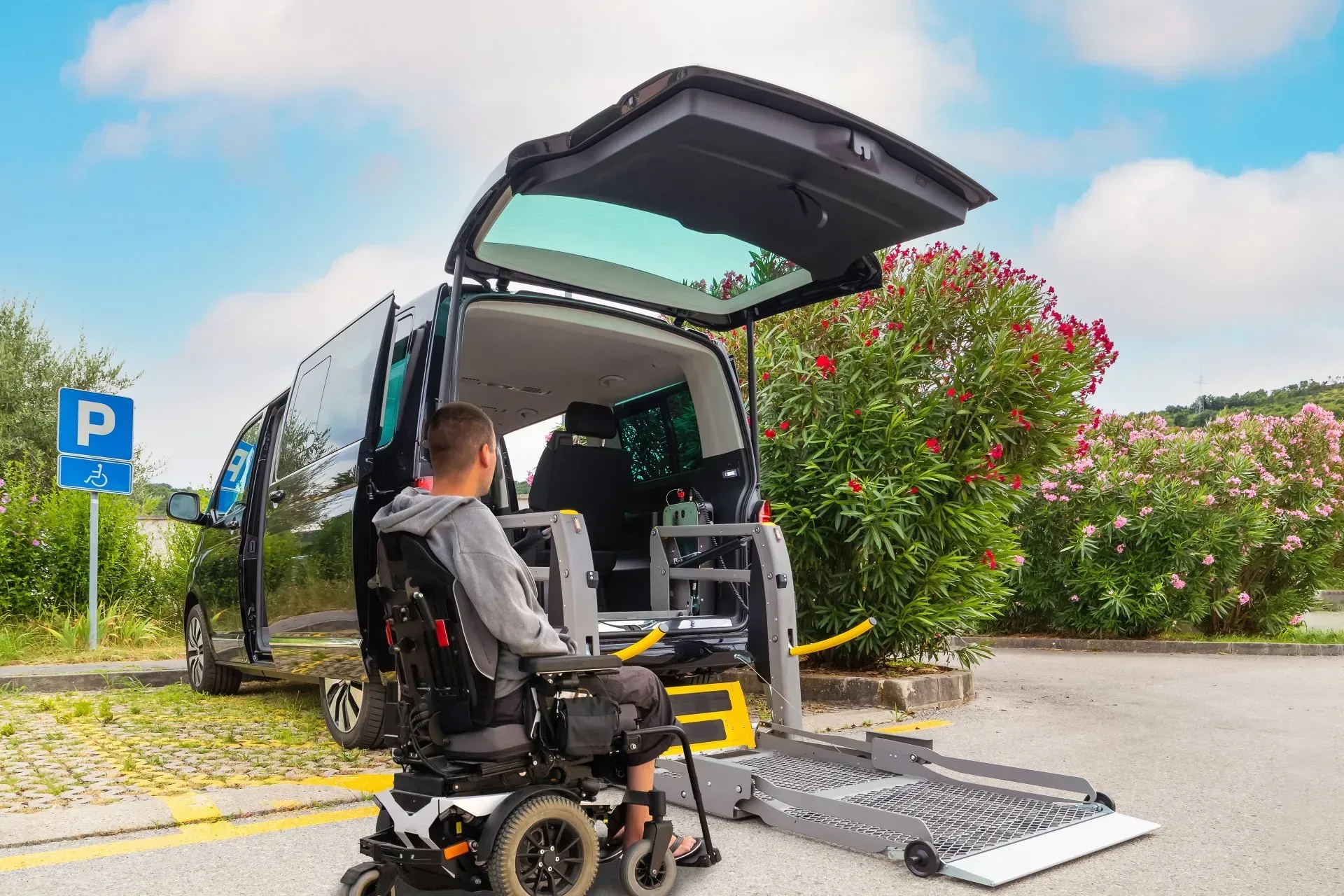 A man in a wheelchair is getting out of a van.