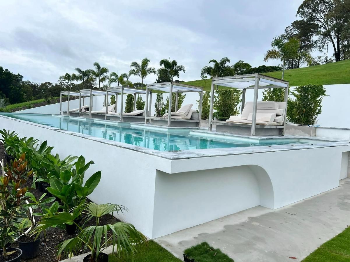 Large Swimming Pool With a Lot of Chairs Around It — Construction 33 in Coolum Beach, QLD
