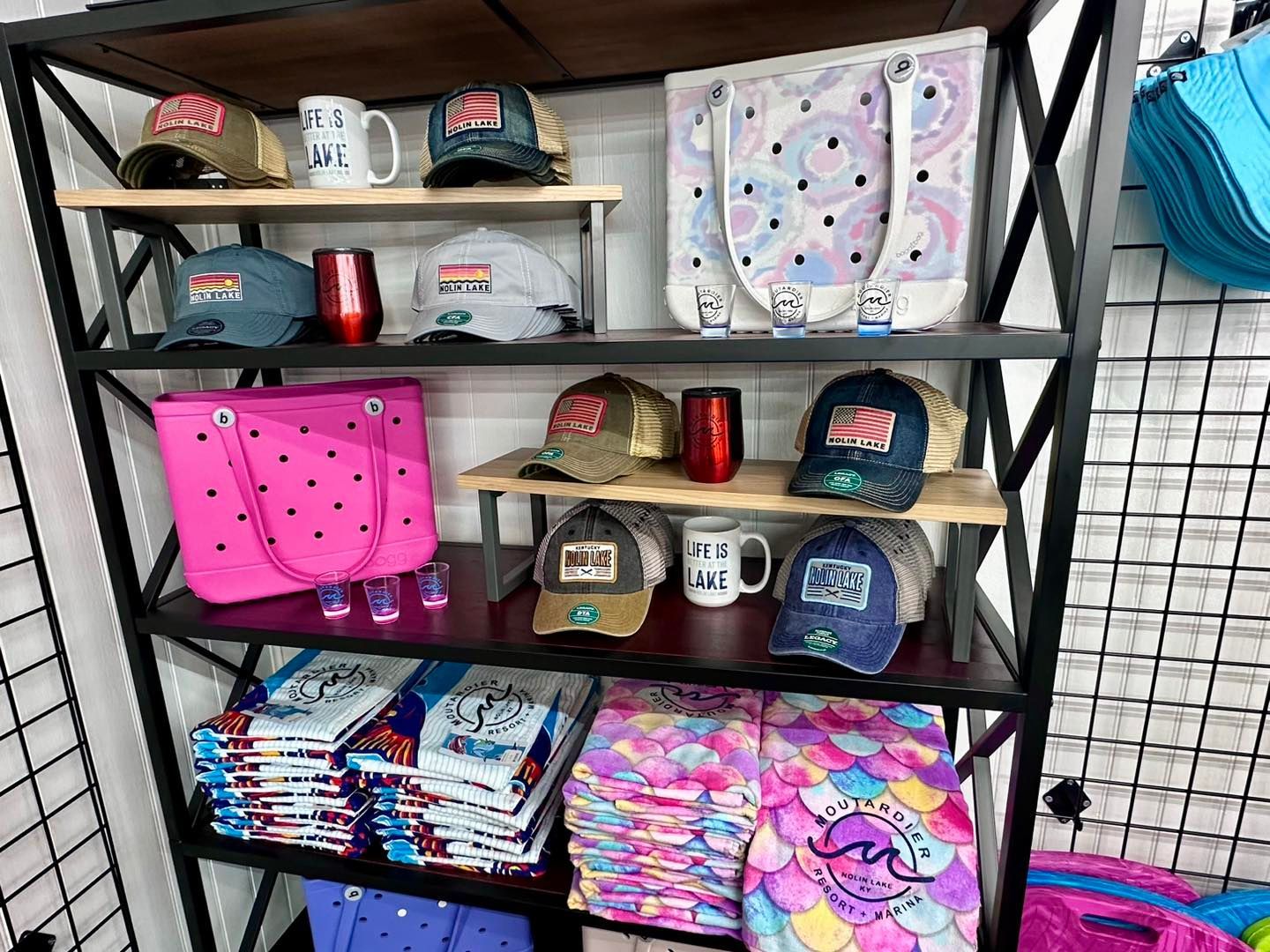 A shelf filled with lots of hats , bags , and mugs.