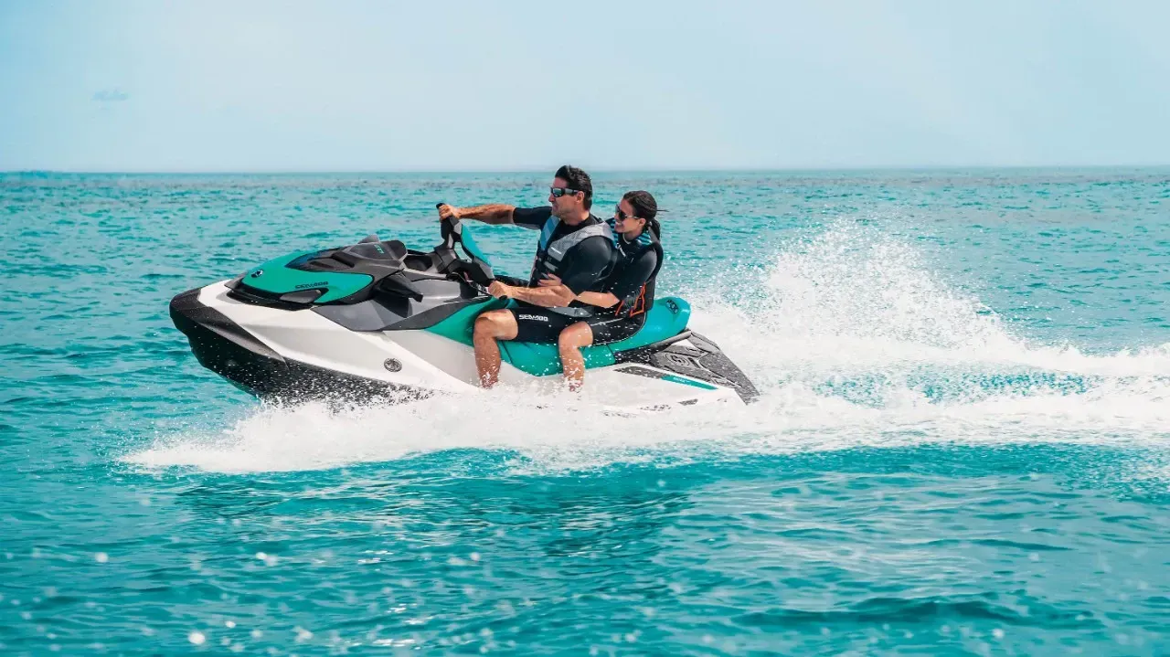 Two people are riding a jet ski in the ocean.