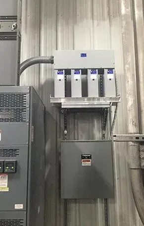 A electrical box is hanging on the wall of a building.