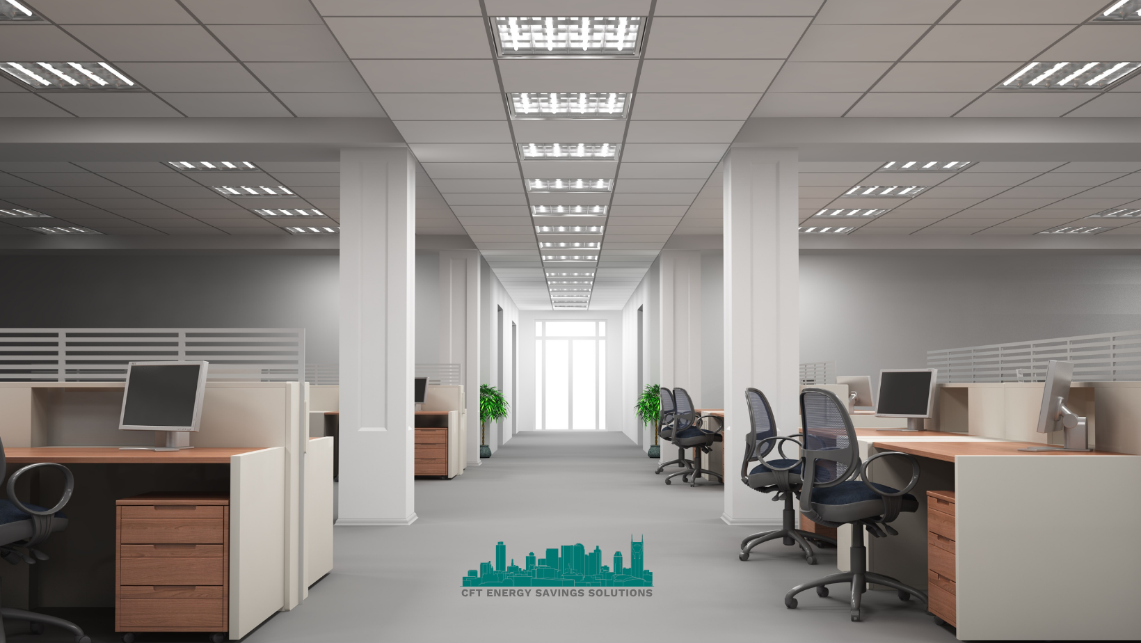 An empty office with cubicles , desks , chairs and computers.
