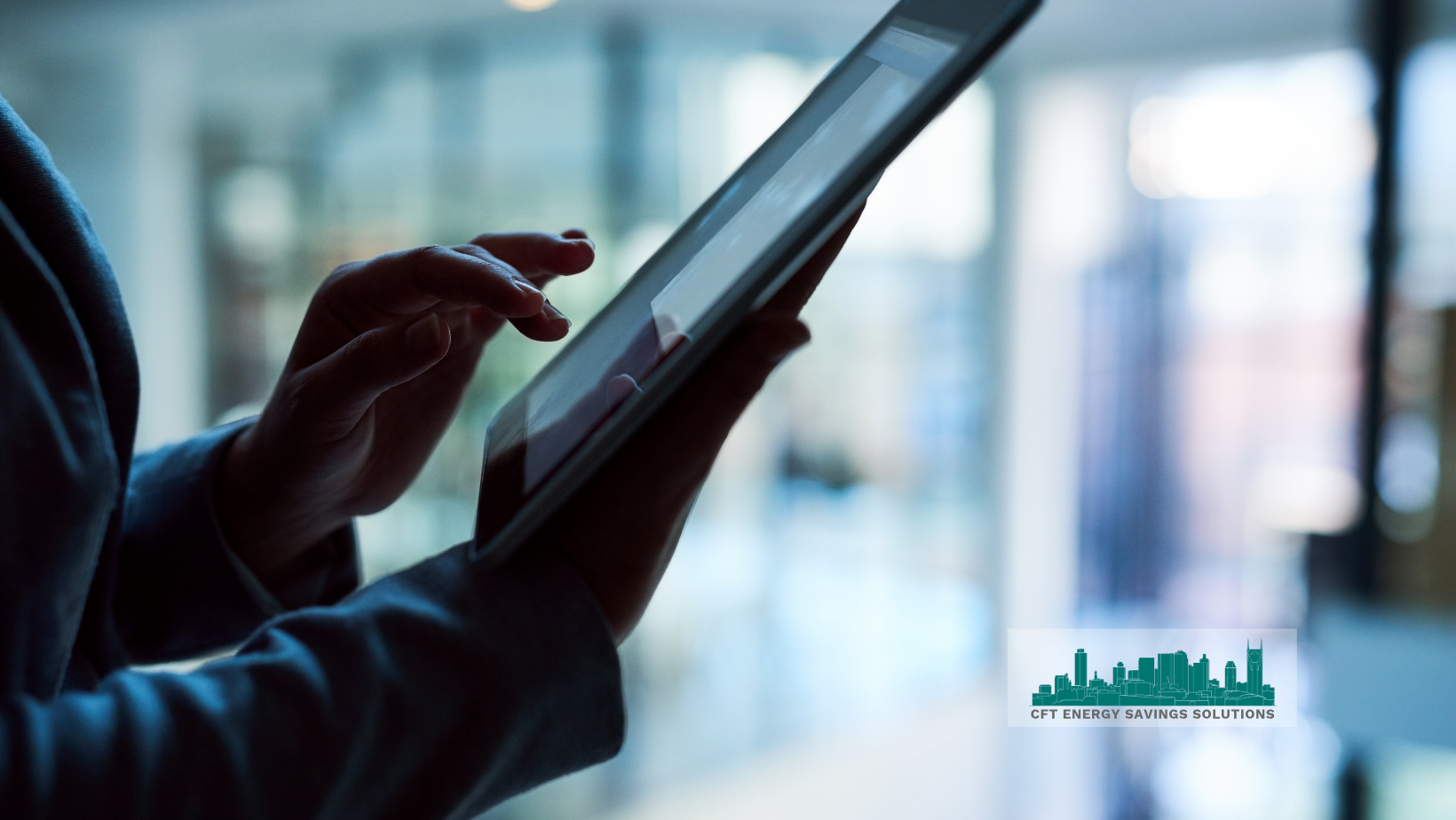A person is using a tablet computer in front of a window.